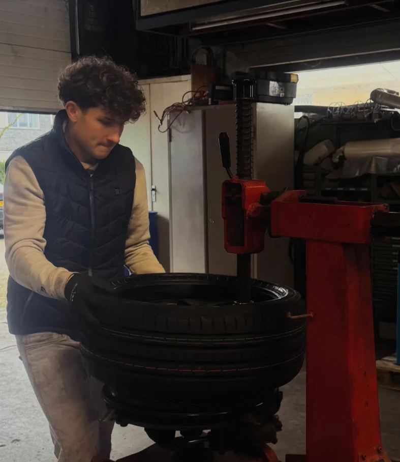 Maxim monteert een band in de werkplaats van BML Bandenservice